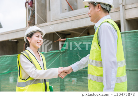 Construction project engineer team joint meeting hand shaking together at construction site 130475878