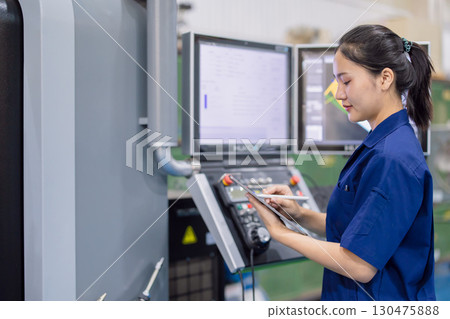 young technician engineer worker with CNC lathe metal machine in modern steel industry factory young technician engineer worker with CNC lathe metal machine in modern steel industry factory 130475888