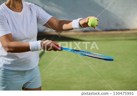 Woman Preparing Tennis Serve on Green Grass Court Outdoor Activity Woman Preparing Tennis Serve on Green Grass Court Outdoor Activity 130475991