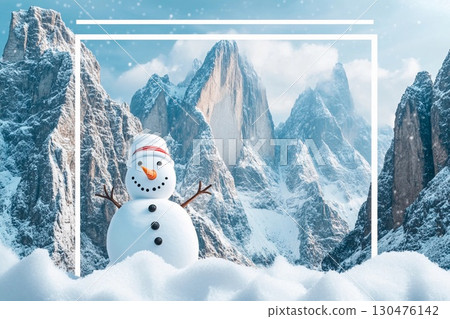 Cheerful snowman stands in snow against majestic mountains during a bright winter day 130476142