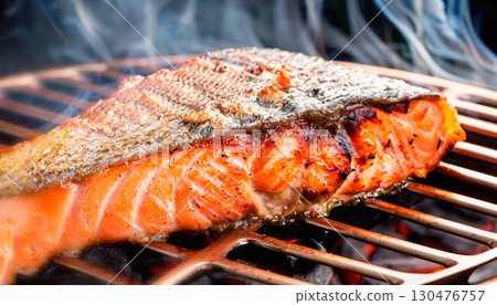The photo of grilled red fish with light smoke and hot coals 130476757