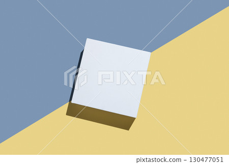 White cube, podium or box with shadow on diagonally divided yellow and blue background. White cube, podium or box with shadow on diagonally divided yellow and blue background. 130477051