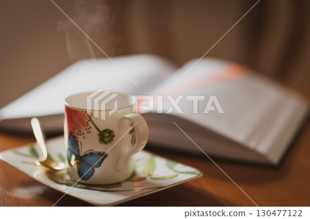 Relaxing moment with coffee and book on a cozy table during a quiet afternoon 130477122