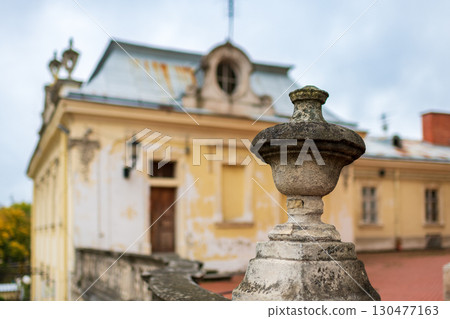 Historic building with ornate stone details under overcast sky in a serene landscape 130477163