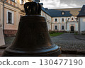 Historic bell stands in courtyard of old monastery at sunset, highlighting intricate details and atmosphere 130477190