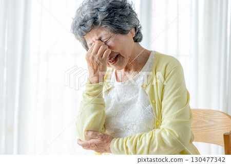 一位老婦人摀著眼角 130477342