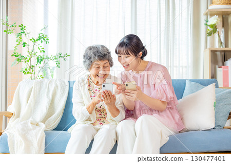 Senior woman playing with her grandchild on a smartphone Senior woman playing with her grandchild on a smartphone 130477401