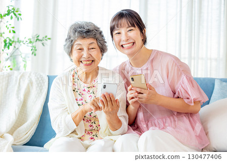 Senior woman playing with her grandchild on a smartphone 130477406