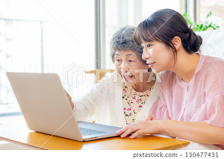 Senior woman learning computer in living room 130477431