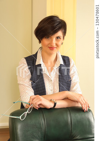 Professional woman posing confidently in a stylish indoor setting during daylight hours Professional woman posing confidently in a stylish indoor setting during daylight hours 130478601