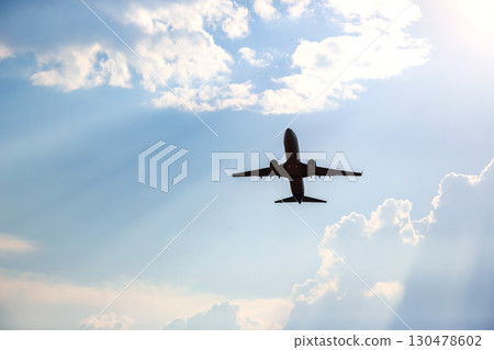 Airplane flying under bright sky with clouds during late afternoon Airplane flying under bright sky with clouds during late afternoon 130478602