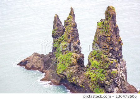 Majestic sea stacks rise from the ocean near Vik, Iceland, showcasing nature's beauty and power 130478606