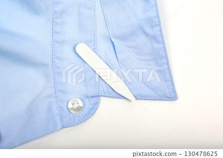 Properly folded collar of a light blue shirt with a collar stay tucked in neatly 130478625