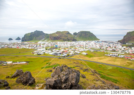 Colorful houses dot the landscape of a quaint Icelandic town near rugged cliffs Colorful houses dot the landscape of a quaint Icelandic town near rugged cliffs 130478776
