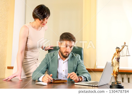 Business meeting between a man and woman in a professional office setting Business meeting between a man and woman in a professional office setting 130478784