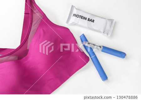 Concept of losing weight with the diabetes drug Ozempic. Sports top and Ozempic syringe pen. Concept of losing weight with the diabetes drug Ozempic. Sports top and Ozempic syringe pen. 130478886