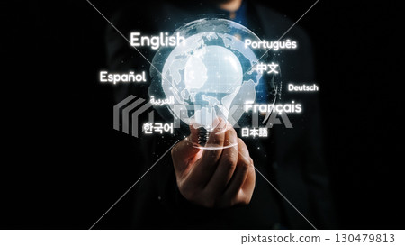 Global Languages in Focus: A Person Holding a Transparent Globe Highlighting Various Languages in a Dark Environment. Qubit 130479813