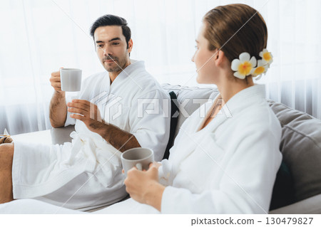 Couple wearing bathrobe relaxing with drinks in luxurious hotel spa. Quiescent 130479827