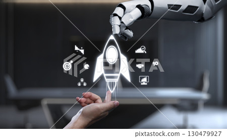 Robotic Hand Reaching to Launch a Rocket Symbolizing Innovation, Technology Advancement, and Human-Machine Collaboration in a Modern Office Environment. Auvana 130479927