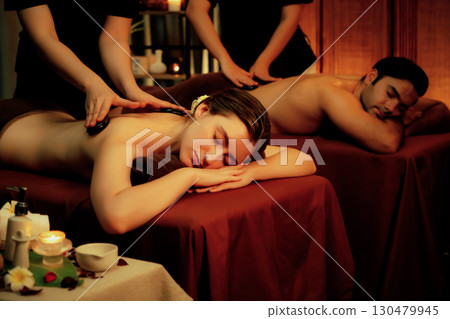 Hot stone massage at spa salon in luxury resort with warm candle light.Quiescent 130479945