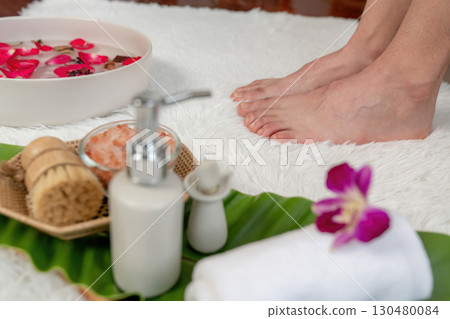 Woman indulges in blissful foot massage at luxurious spa salon. Quiescent Woman indulges in blissful foot massage at luxurious spa salon. Quiescent 130480084