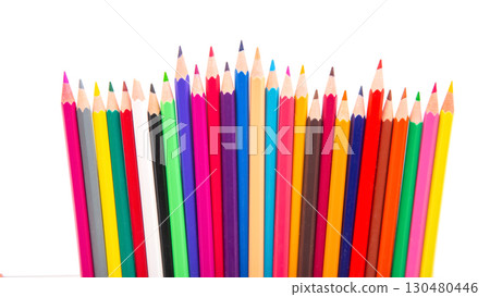 A vibrant row of sharpened colored pencils in various hues, arranged in a wave-like pattern 130480446