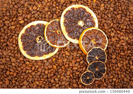 A vibrant close-up of dried orange slices nestled among roasted coffee beans A vibrant close-up of dried orange slices nestled among roasted coffee beans 130480449