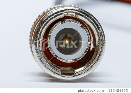 Macro photo of BNC connector on white background. Metal connector with central contact used for coaxial cables in video communication and radio equipment. BNC connector crimping. 130481825