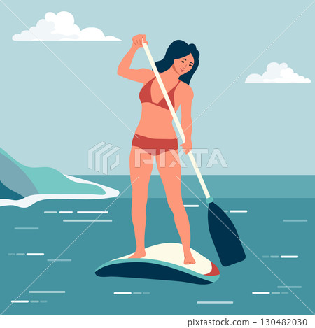 Woman paddleboarding on blue ocean under clear sky with clouds, wearing a bikini and smiling 130482030