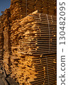 Large pile of wooden boards with blue sky background 130482095