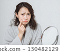 一位患有皮膚粗糙的女性照鏡子 | 皮膚護理、痤瘡、美容 130482129