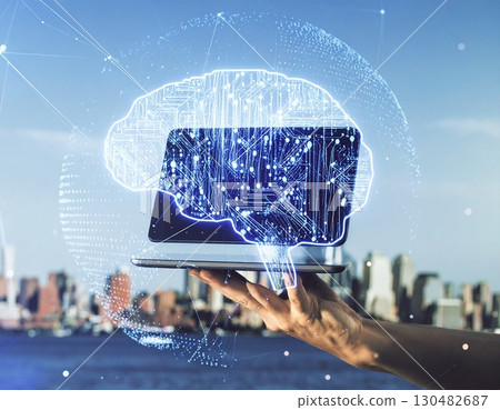 Digital Brain Innovation: A hand gracefully holds a digital tablet, from which a luminous, intricately designed brain composed of interconnected nodes and lines emerges. 130482687