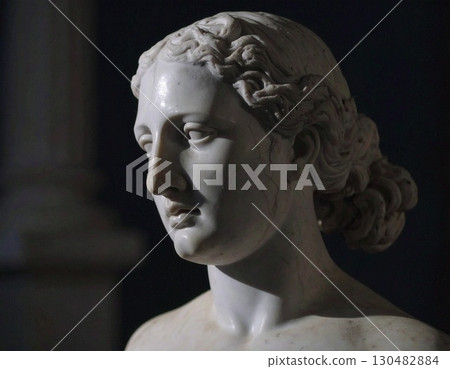 A cracked statue's delicate face evokes a sense of history and fragility 130482884