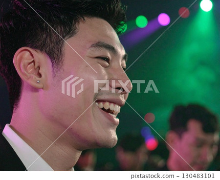 A man exhaling smoke, thoughtfully gazing at the viewer, under the city lights A man exhaling smoke, thoughtfully gazing at the viewer, under the city lights 130483101