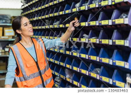 Woman engineer technician staff work in factory products barcode scan inventory parts storage room Woman engineer technician staff work in factory products barcode scan inventory parts storage room 130483463