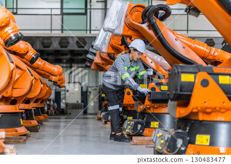 Engineer woman working in machine factory. Indian female engineer work in robot arm assembly plant Engineer woman working in machine factory. Indian female engineer work in robot arm assembly plant 130483477