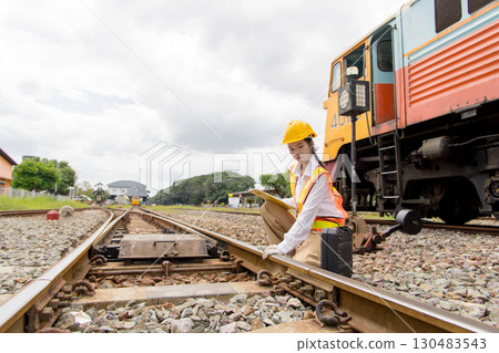Asian young teen train engineer work check inspect service maintenance old locomotive railway track 130483543