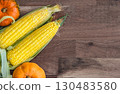 Thanksgiving background with autumnal gourds on rustic wooden table. Autumn harvest. Small pumpkins and sweet corn are lying on wooden background. Top view. Flat lay composition frame, copy space 130483580