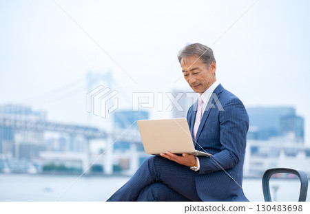 Senior man using a laptop outdoors 130483698