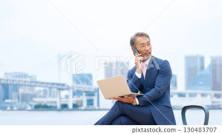 Senior man using a laptop outdoors 130483707