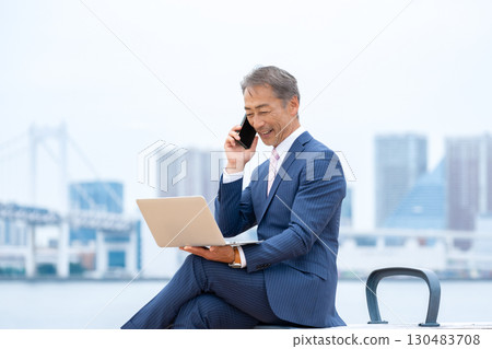 Senior man using a laptop outdoors Senior man using a laptop outdoors 130483708