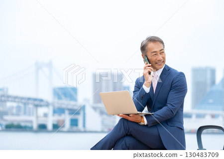 一位老人在戶外使用筆記型電腦 130483709