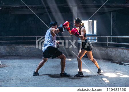 Thai boxing, Women fighter training kick boxing with trainer in ruin building ,Asian martial arts Thai boxing, Women fighter training kick boxing with trainer in ruin building ,Asian martial arts 130483868