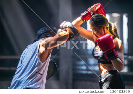Thai boxing, Women fighter training kick boxing with trainer in ruin building ,Asian martial arts Thai boxing, Women fighter training kick boxing with trainer in ruin building ,Asian martial arts 130483869