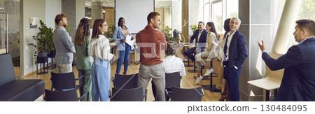 Group of business men and women meeting in office and learning to make public speeches 130484095