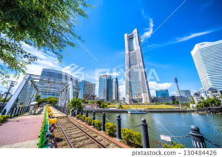 A rare sight in the Yokohama cityscape of Japan: exposed rails...View of Yokohama Landmark Tower and the bustling Nippon Maru from the railway road... A rare sight in the Yokohama cityscape of Japan: exposed rails...View of Yokohama Landmark Tower and the bustling Nippon Maru from the railway road... 130484426