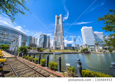 A rare sight in the Yokohama cityscape of Japan: exposed rails...View of Yokohama Landmark Tower and the bustling Nippon Maru from the railway road... A rare sight in the Yokohama cityscape of Japan: exposed rails...View of Yokohama Landmark Tower and the bustling Nippon Maru from the railway road... 130484453