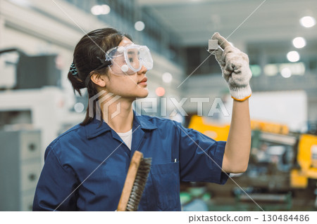 young teen technician Industry engineer student polishing metal part in university workshop young teen technician Industry engineer student polishing metal part in university workshop 130484486
