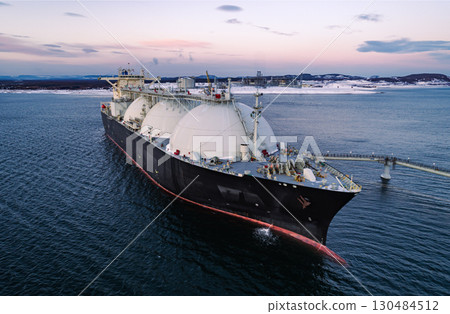 Aerial of Liquified Natural Gas LNG carrier moored to a small gas terminal. Fuel crisis. Sanctions Aerial of Liquified Natural Gas LNG carrier moored to a small gas terminal. Fuel crisis. Sanctions 130484512