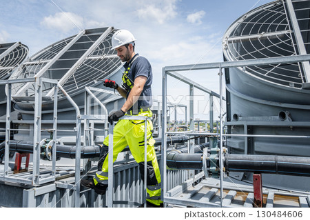 Professional worker servicing HVAC building cooling tower, Industry air conditioner service 130484606